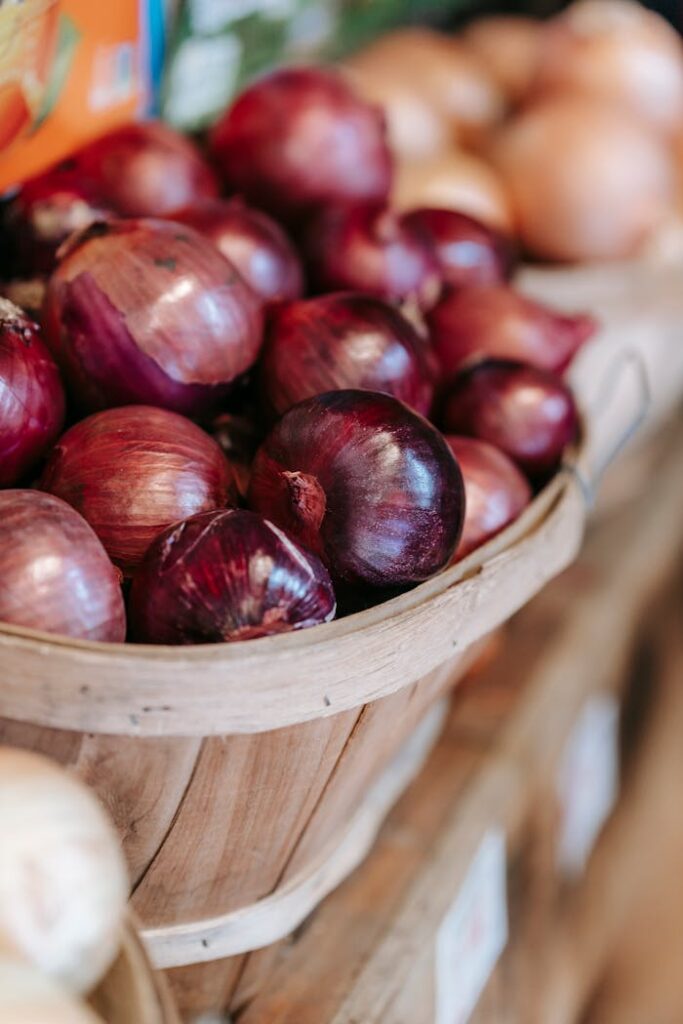 Pile of red onions in straw basket in grocery market